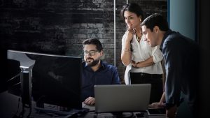 Drei Mitarbeiter arbeiten zusammen produktiv am Intel Modern Workplace